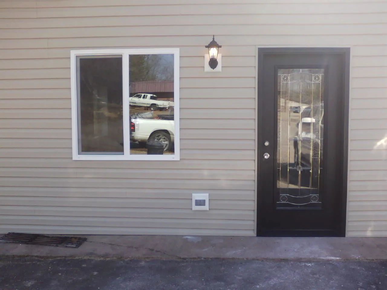 New siding, window and entry door on the side of an addition in Chaska