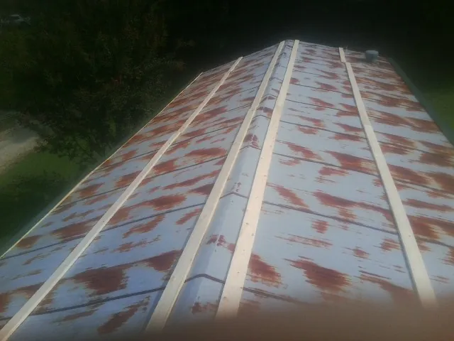 Rusted metal roof panels with new wood purlins before replacement — Storm Damage Roof Repair in Chaska by Roofing Brothers